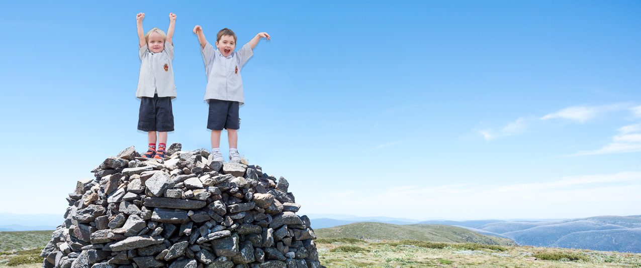 Boys standing on a rock